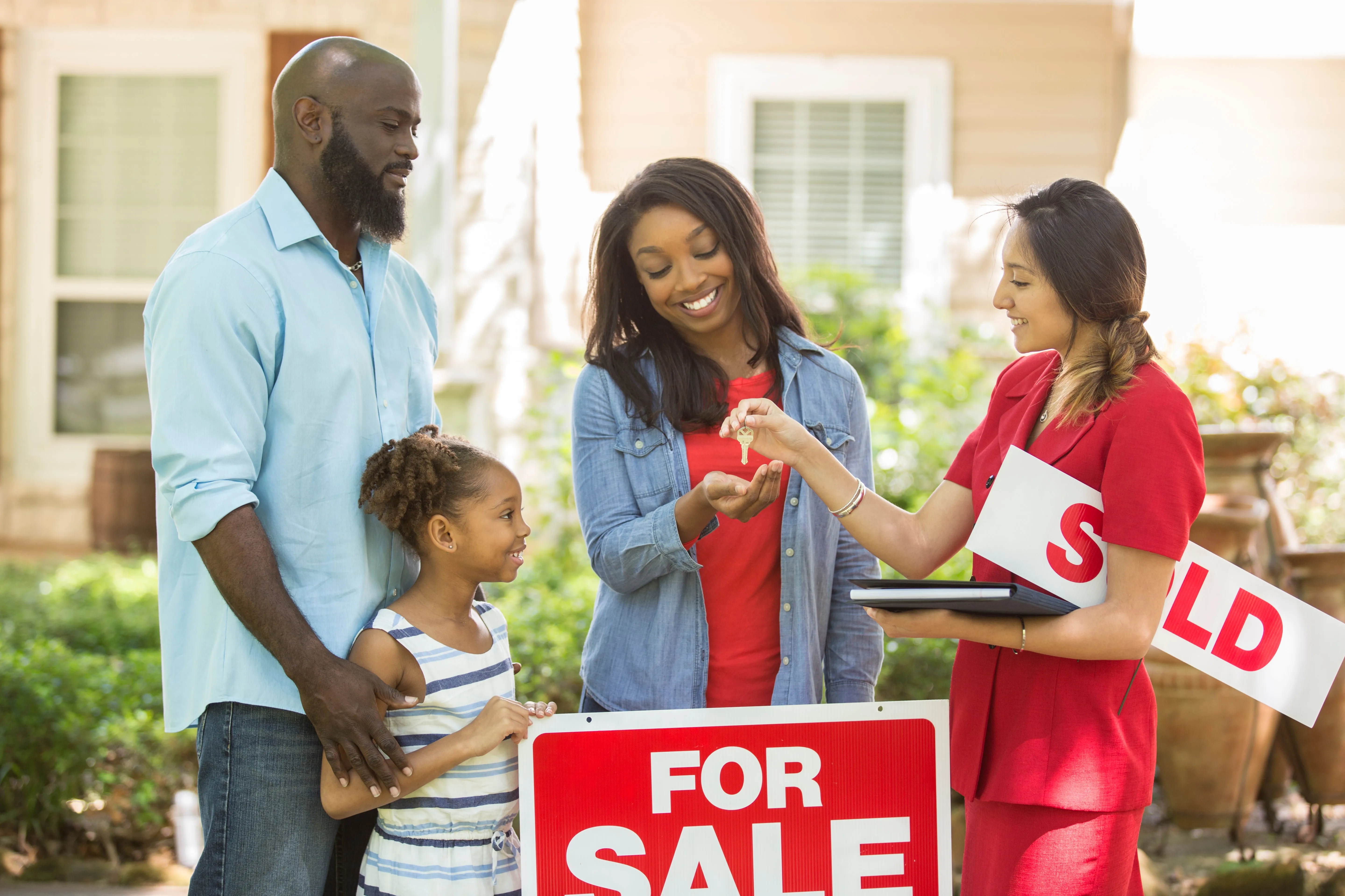 Happy family receiving keys to their new home from real estate agent